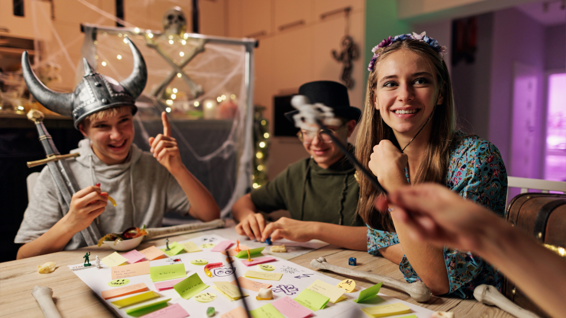 enfants déguisés assis autour d'une table et jouant à un jeu de société